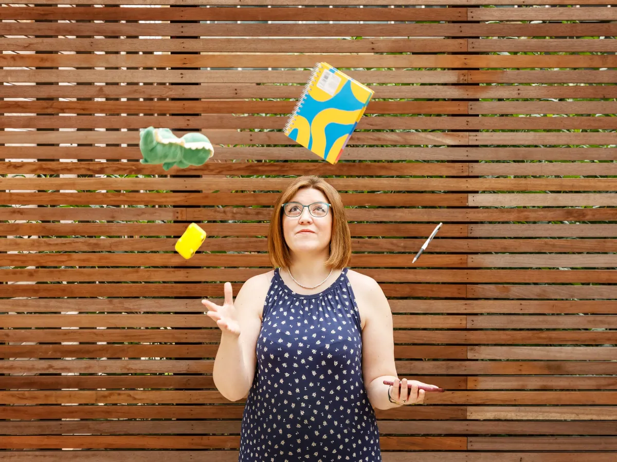 Alicia, Virtual Assistant at The Admin Den, juggling a notebook, toy crocodile, sponge, pen and phone, representing the juggle of work and family life.